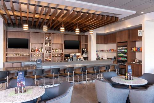 a bar in a restaurant with two tables and chairs at Hyatt Place Detroit/Royal Oak in Royal Oak