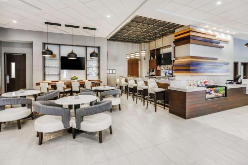 a restaurant with tables and chairs and a bar at Hyatt Place Greenville Downtown in Greenville