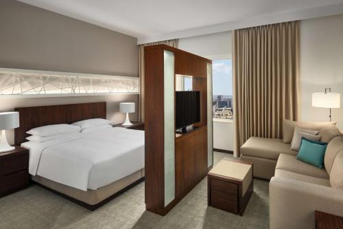a bedroom with a bed and a tv and a couch at Hyatt House Jeddah Sari Street in Jeddah