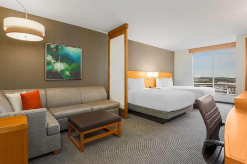um quarto de hotel com uma cama e um sofá em Hyatt Place Austin Cedar Park em Cedar Park
