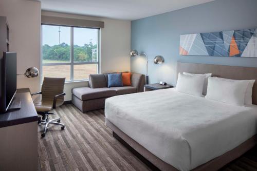 ein Hotelzimmer mit einem Bett und einem Stuhl in der Unterkunft Hyatt House Charleston/Mount Pleasant in Charleston