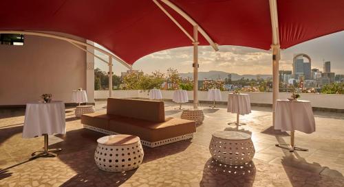 a patio with a couch and tables and a view of the city at Hyatt Regency Addis Ababa in Addis Ababa