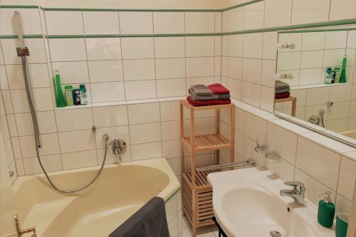 a bathroom with a tub and a sink and a mirror at Bergblick am Kaminfeuer in Aschau im Chiemgau