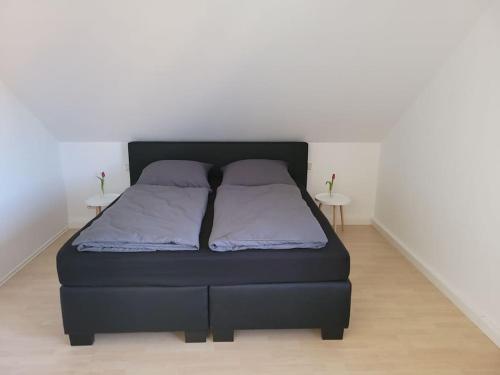 a bed in a room with two tables at Ruhige Ferienwohnung auf dem Land in Starzach