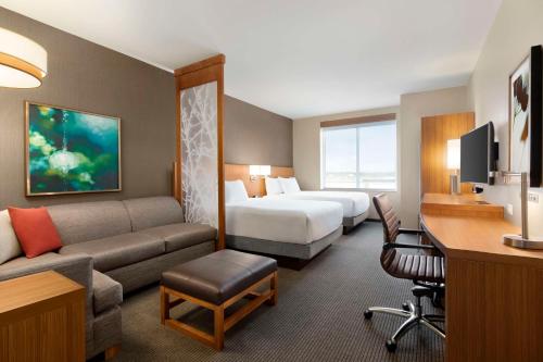 a hotel room with a bed and a couch at Hyatt Place Virginia Beach Town Center in Virginia Beach
