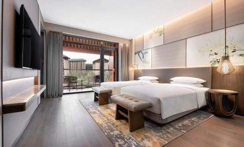 a bedroom with two beds and a flat screen tv at Hyatt Regency Beijing Shiyuan in Yanqing