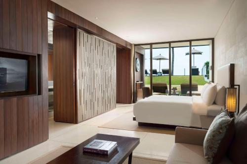 a bedroom with a bed and a living room at Alila Seminyak in Seminyak