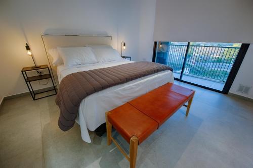 內烏肯的住宿－Apartemanto Luxury vistas Nqn 1 bed，一间卧室配有一张床铺和一张桌子,并设有一个阳台