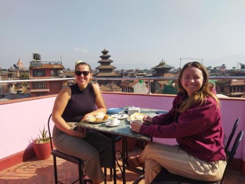 two women sitting at a table on a roof at HOTEL RUPAKOT AND ROOFTOP RESTAURANT in Bhaktapur