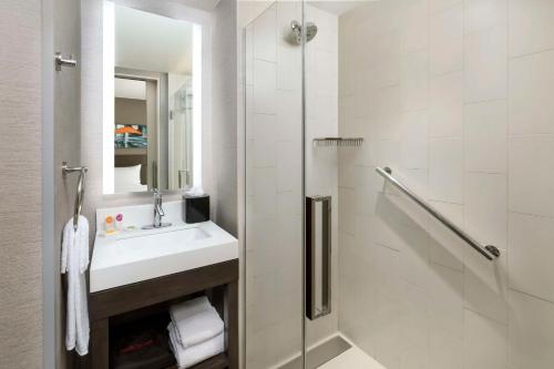 La salle de bains blanche est pourvue d'un lavabo et d'une douche. dans l'établissement Hyatt Place New York City/Times Square, à New York