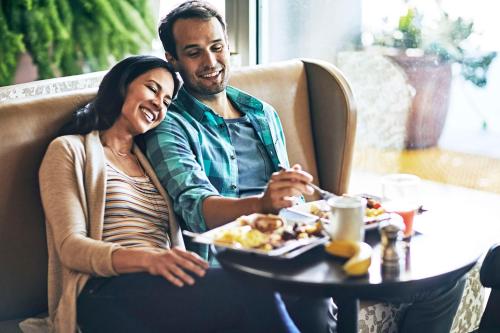 a man and a woman sitting at a table eating food at Hyatt Place New York City - Times Square in New York