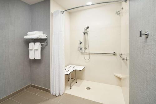 a bathroom with a shower and a toilet and a sink at Hyatt Place Melbourne - Palm Bay - I-95 in Melbourne