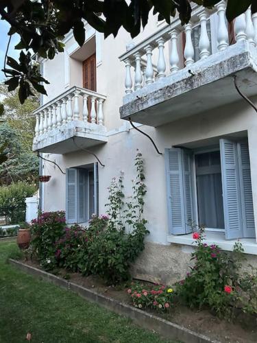 a white building with blue shutters and a balcony at La Casa di Rena in Áno Poróïa