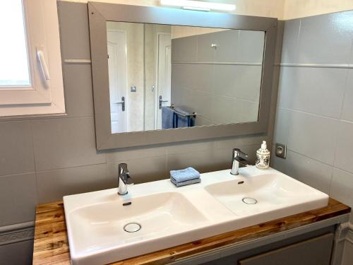 La salle de bains est pourvue d'un lavabo blanc et d'un miroir. dans l'établissement Résidence Alpha Centauri, à Carcassonne