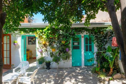 a house with a green door and ivy at Casa Blanca Hostel in Tarija