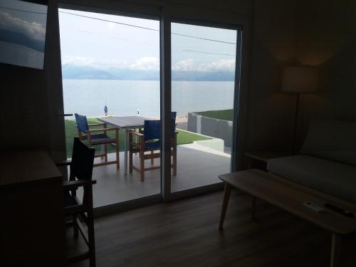 a living room with a table and a view of the ocean at Stavento in Diakopto