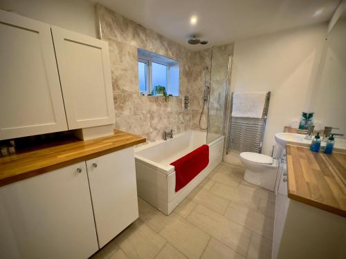 a bathroom with a tub and a toilet and a sink at Victorian Cottage Like Charm with Modern Comforts in Bristol