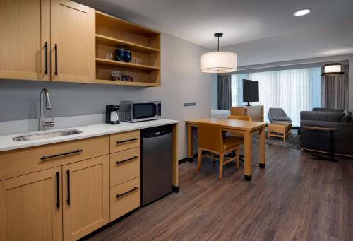 a kitchen and living room with a table and a dining room at Hyatt Place Boston/Seaport District in Boston
