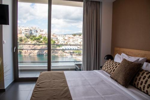 um quarto com uma cama e uma grande janela em Remvi apartments em Agios Nikolaos