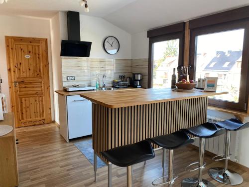 a kitchen with a wooden counter and stools in it at Unter dem Dach mit Parkplatz in Bremen