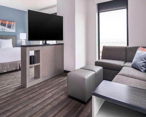 a hotel room with a couch and a bed and a television at Hyatt House Allentown-Lehigh Valley in Allentown
