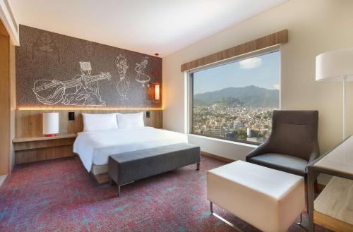 1 dormitorio con 1 cama, 1 silla y 1 ventana en Hyatt Place Kathmandu, en Katmandú