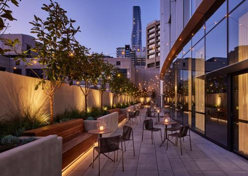 a rooftop patio with tables and chairs on a building at Hyatt Centric Melbourne in Melbourne