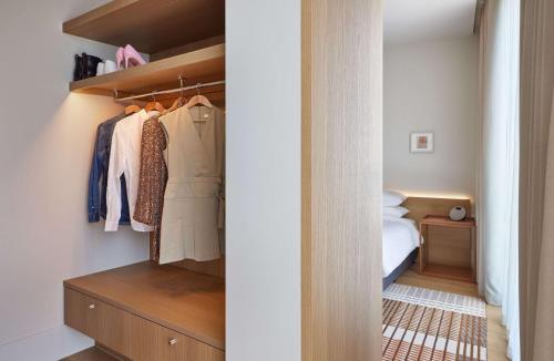 a closet with a dresser and a bed in a room at Hyatt Centric Melbourne in Melbourne