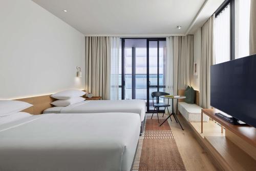 a hotel room with two beds and a flat screen tv at Hyatt Centric Melbourne in Melbourne