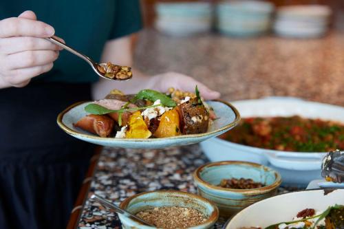 a person holding a spoon with a bowl of food at Hyatt Centric Melbourne in Melbourne