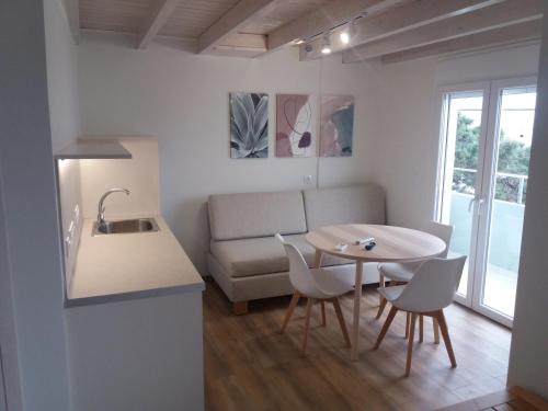 a kitchen and living room with a table and a couch at Stavento in Diakopto