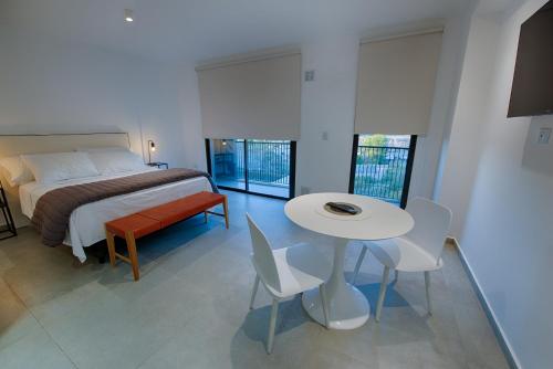 ネウケンにあるApartamento Luxury Vistas Eのベッドルーム1室(ベッド1台、テーブル、椅子付)