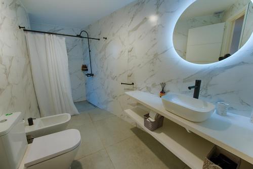 Baño blanco con lavabo y espejo en Apartamento Luxury Vistas E en Neuquén