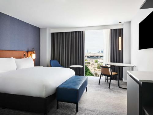 a hotel room with a bed and a desk at Hyatt Regency London Stratford in London