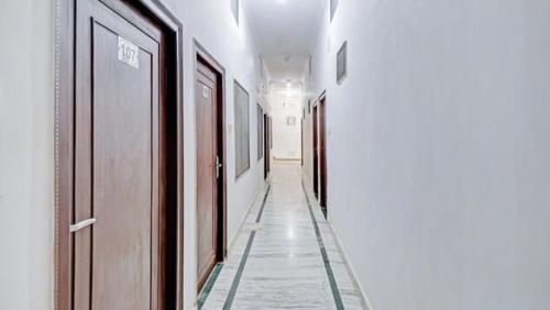 a hallway of a building with white walls and a hallwayngth at Backpackers Dinesh Home Stay in Khajurāho