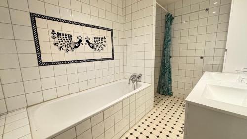 a bathroom with a bath tub and a sink at Oslo-Frogner in Oslo