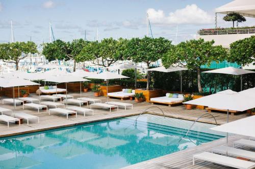 檀香山的住宿－Hilton Vacation Club The Modern Honolulu，一个带躺椅和遮阳伞的室外游泳池