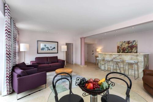 a living room with a couch and a table with a bowl of fruit at The Astor by LuxUrban, Trademark Collection by Wyndham in Miami Beach