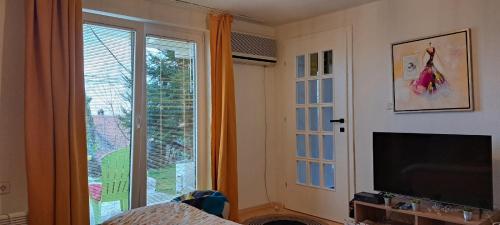 a living room with a large window and a television at Hello Skopje! in Skopje