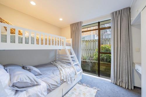um quarto com um beliche e uma grande janela em Entire house with pool, spa em Auckland