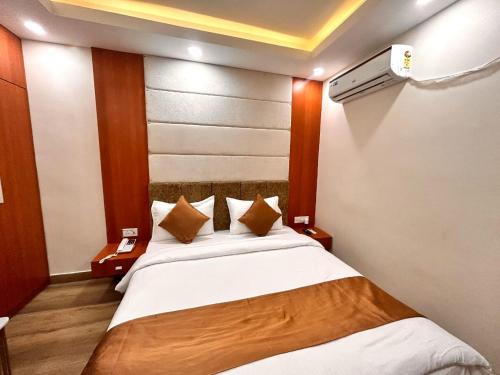 a bedroom with a large bed with white sheets and pillows at HOTEL EDEN GARDEN in Āsansol