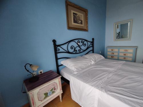 ein blaues Schlafzimmer mit einem Bett und einem Nachttisch in der Unterkunft Grammatikis house in Vourliótai
