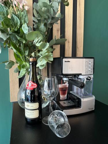 a bottle of wine and glasses on a table with a blender at Blisko Gór Szyndzielnia in Bielsko-Biała