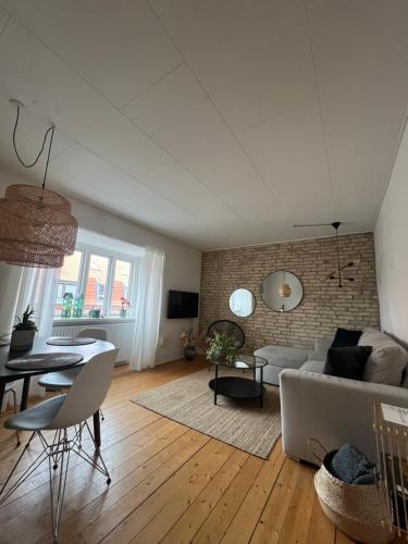 ein Wohnzimmer mit einem Sofa und einem Tisch in der Unterkunft Anna in Aalborg