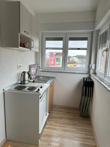 uma pequena cozinha com um fogão e duas janelas em Apartments Modana em Medjugorje