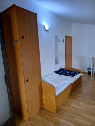 um quarto com uma cama e um armário de madeira em Apartments Modana em Medjugorje