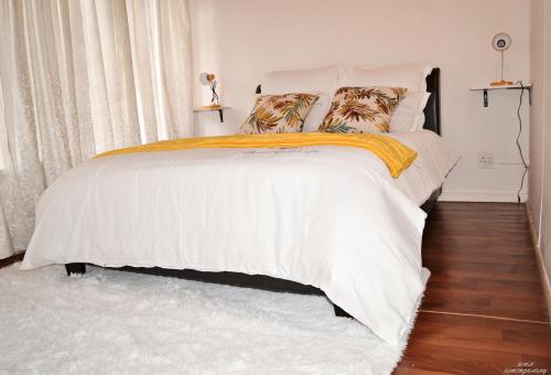 Johannesburg的住宿－Sunshine Room，一间卧室配有带白色床单和枕头的床。