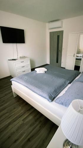 ein Schlafzimmer mit einem großen Bett und einem TV in der Unterkunft Na domečku in Bořetice