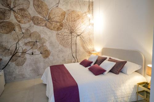 - une chambre dotée d'un lit avec un mur à motifs floraux dans l'établissement Agriturismo Ciriè, à Cassano delle Murge