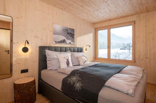 ein Schlafzimmer mit einem Bett in einem Holzzimmer in der Unterkunft Haus Valtellina in Galgenul